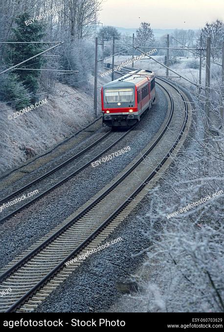 Passengers train running through nature on a cold morning day of December, near the german city Schwabisch Hall