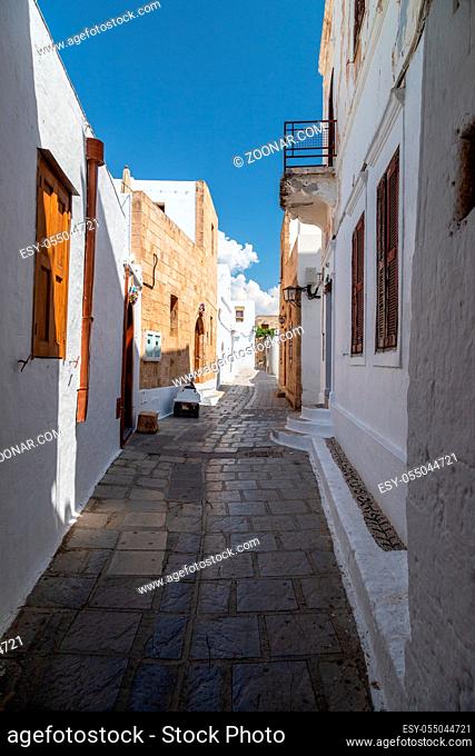 Narrow street with white houses in Lindos on Greek island Rhodes