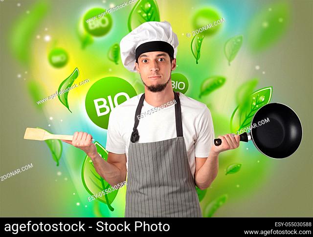 Green bio leaves concept and cook portrait with kitchen tools