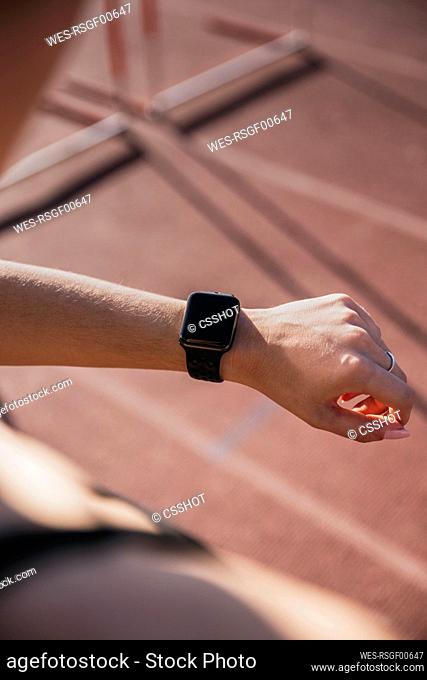 Sportswoman checking smart watch during sunny day