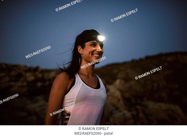 Sportive woman with headlamp in the evening