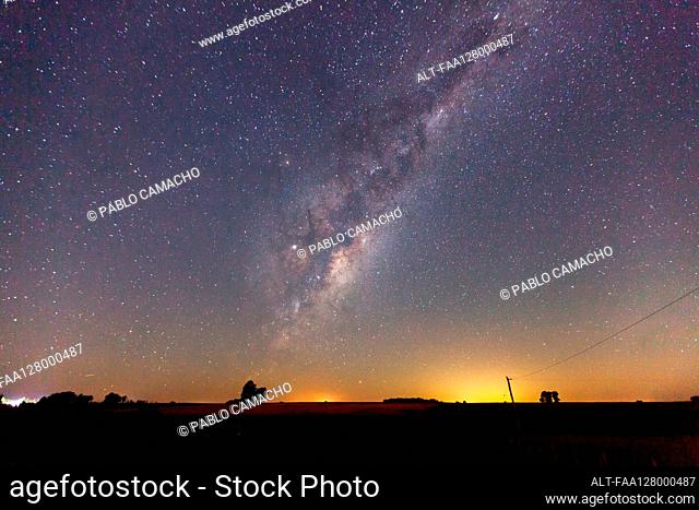 Scenic view of milky way over rural landscape
