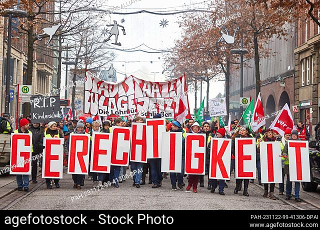 dpatop - 22 November 2023, Hamburg: Participants at a rally on Mönckebergstraße hold signs reading ""Justice"". The trade unions Verdi and GEW called on...