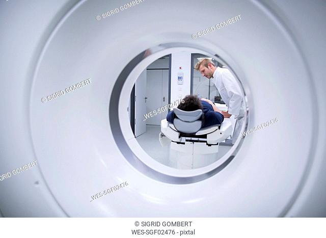 Patient in hospital during CT examination and radiologist