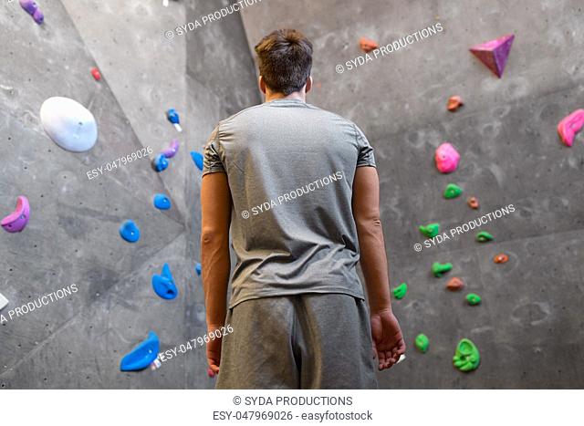 young man at indoor climbing wall in gym