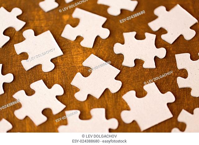 business and connection concept - close up of puzzle pieces on wooden surface