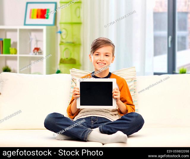 smiling boy with tablet computer at home