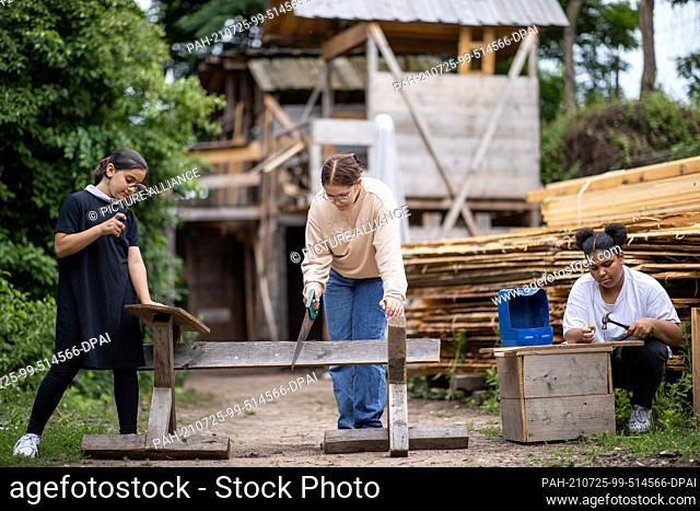 29 June 2021, Bavaria, Nuremberg: The children Shahid (l-r), Runa and Amina work on wooden slats at the Gostenhof active playground