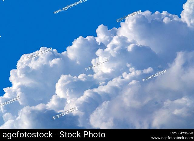 sunny illuminated cumulus cloud closeup in blue sky ambiance
