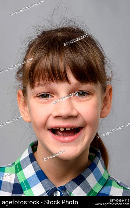 Portrait of a funny ten-year-old girl with a cheerful smile, European appearance, close-up