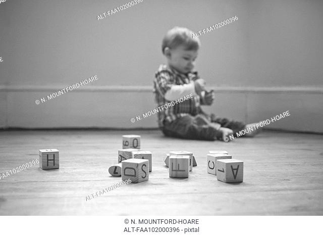 Baby boy playing on floor in nursery