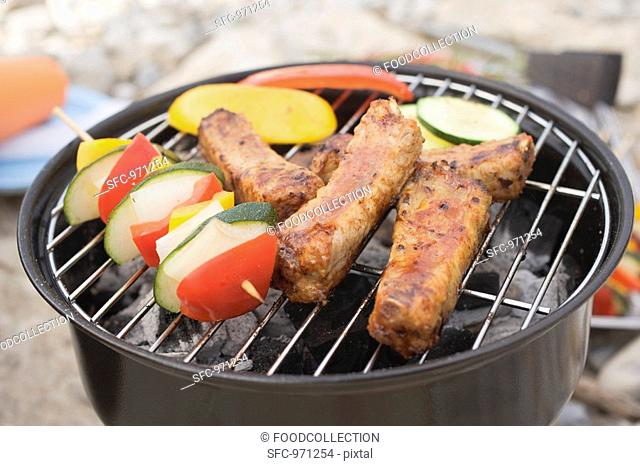 Ribs and vegetables on barbecue out of doors