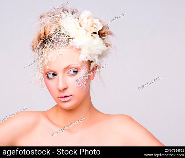 Portrait of young lady with creative winter professional make-up. Beautiful lady with elegant hairdo posing isolated on white background