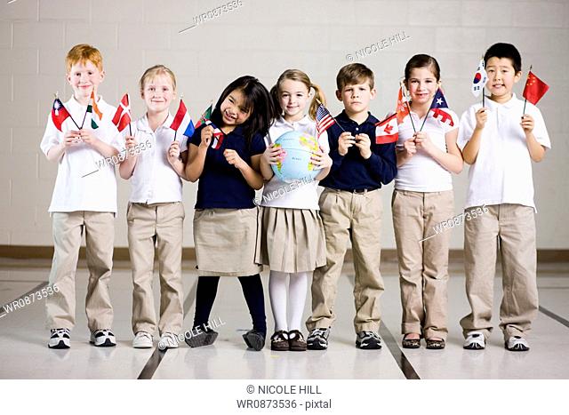 school children waving flags of different countries