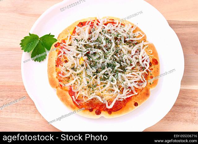 small fish shirasu pizza on a plate with wooden table