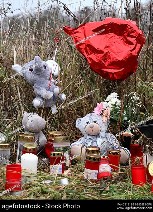 18 December 2023, Mecklenburg-Western Pomerania, Pasewalk: Candles, stuffed animals and flowers are placed along a fence to an overgrown property where the...