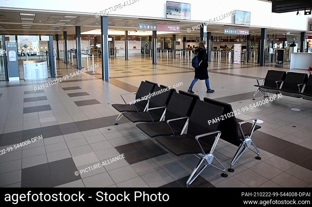 22 February 2021, Brandenburg, Schönefeld: A woman walks through the deserted check-in hall on the last day of operations at Terminal 5 of the capital's airport...