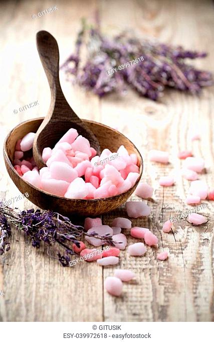 Homeopathic sea salt, lavender dry flowers and wooden surface