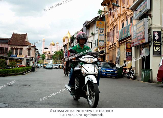 A man is riding a motorbike in Kuching, Malaysia, 21 October 2014. Photo: Sebastian Kahnert - NO WIRE SERVICE - | usage worldwide