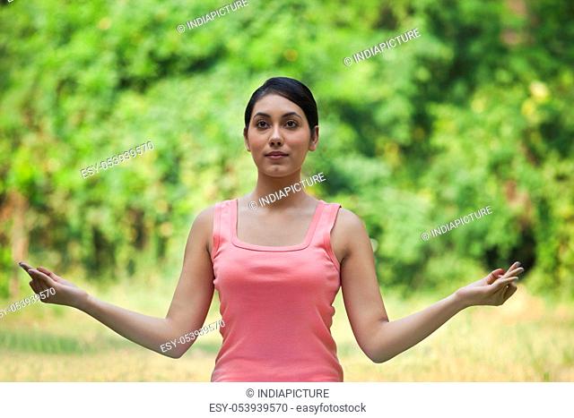 Woman in lawn practicing yoga and looking away