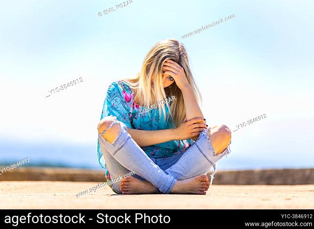 Alone under the sun adolescent teen girl sad peeking one eye at camera