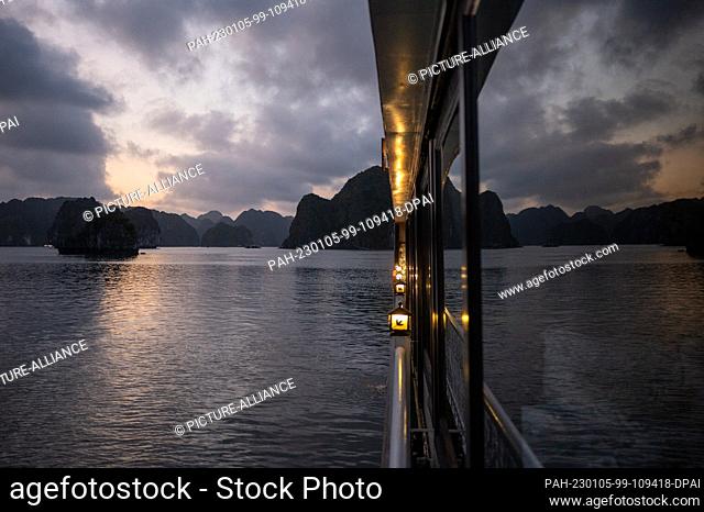 18 November 2022, Vietnam, Ha Long: Rock formations in Ha Long Bay reflected in the window of a boat at sunset. Photo: Sebastian Kahnert/dpa