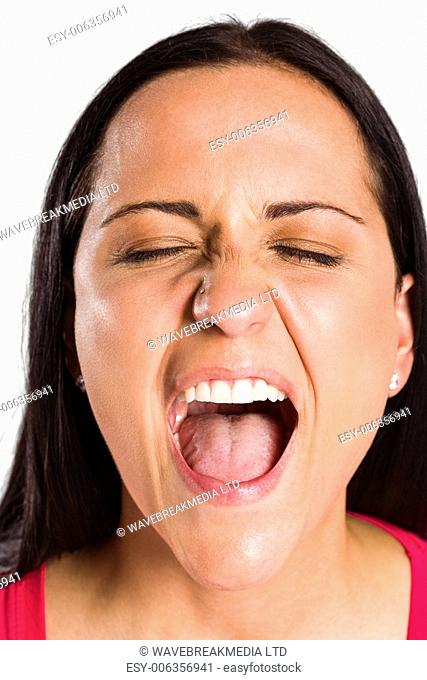 Angry young brunette shouting in close up on white background