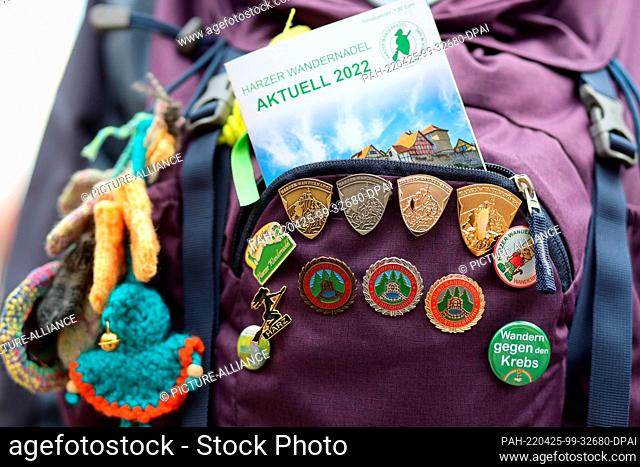 24 April 2022, Saxony-Anhalt, Quedlinburg: Hiking badges stuck to a hiking backpack. Hundreds of hiking enthusiasts met in Quedlinburg for this year's season...