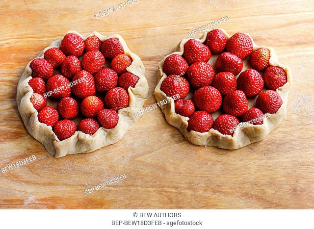 Strawberry tart before baking on wooden table. Summer dessert