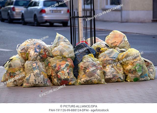 15 October 2019, Saxony, Meißen: A mountain of yellow sacks of recyclable packaging waste lies on the sidewalk. Photo: Jens Büttner/dpa-Zentralbild/ZB