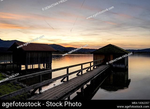 Boat huts at Kochelsee in the Bavarian foothills of the Alps in the evening glow