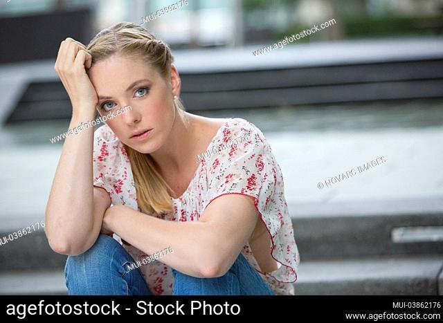 Young woman sitting on stairs, portrait