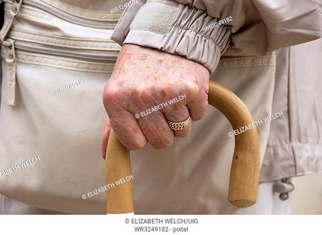 Elderly woman using a walking stick to help with mobility
