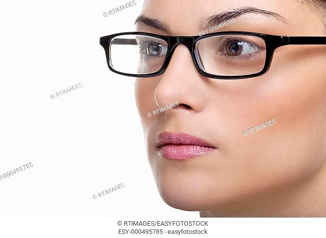 Close up of an attractive female wearing black glasses looking out of frame