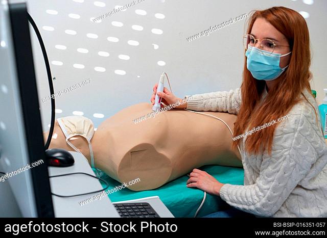 Students and their teacher during an echography simulation workshop on a robot mannequin