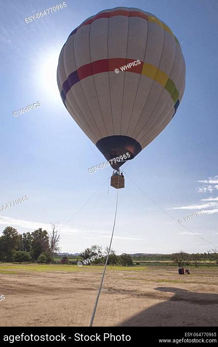 Ascending hot air balloon. Air-vehicle tethered to three fixed points