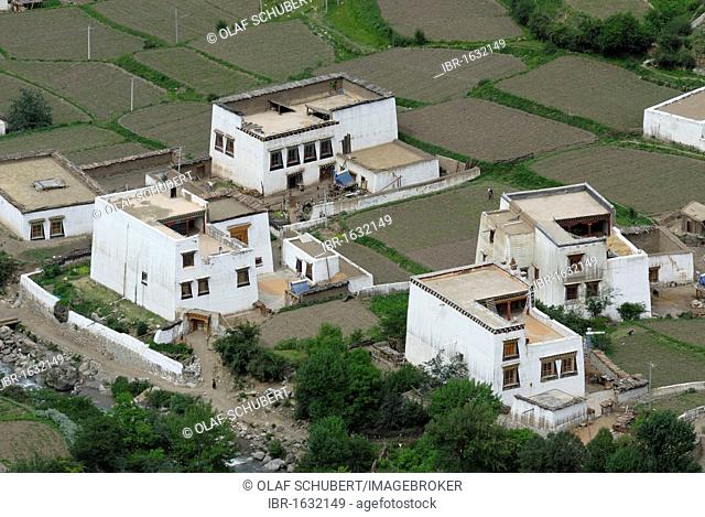 View on the Tibetan architecture of a small village, Tibetan houses in a steep canyon with field terraces for cultivation, Xiang Cheng, Chaktreng, Kham, Sichuan