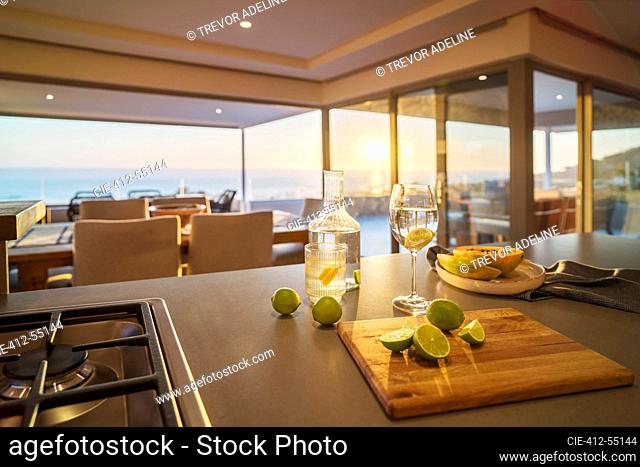 Water and fresh lime slices on luxury kitchen counter with ocean view