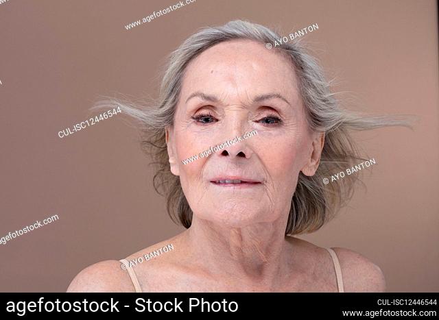 Studio shot of senior woman with windswept hair