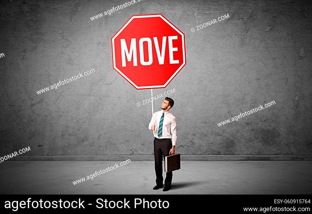 Young business person holding road sign with MOVE inscription, new rules concept