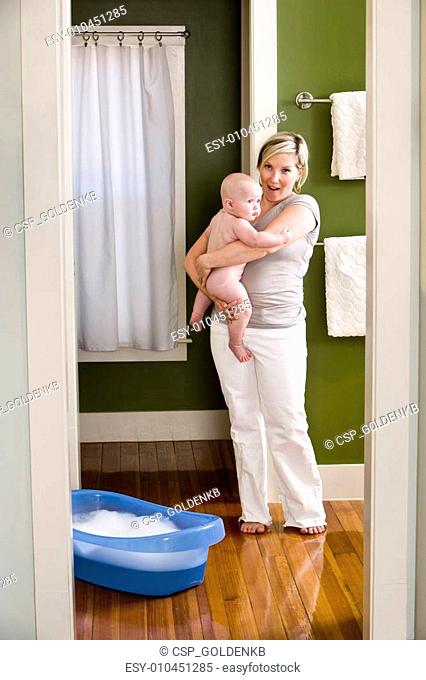 Mother preparing baby for bath