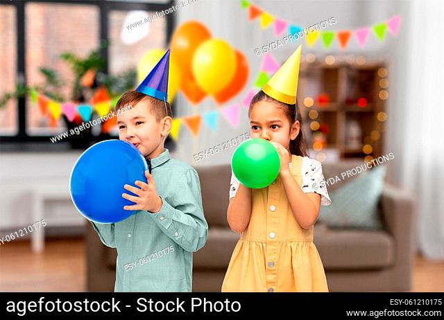 happy children blowing balloons on birthday party