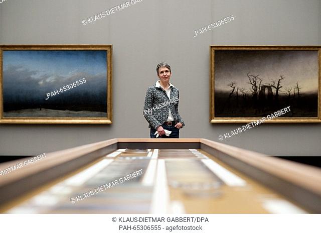 The leading conservator at the Alte Nationalgalerie Berlin, Kristina Moesl poses in front of the restored paintings 'The Monk by the Sea' (L, 1808-1810