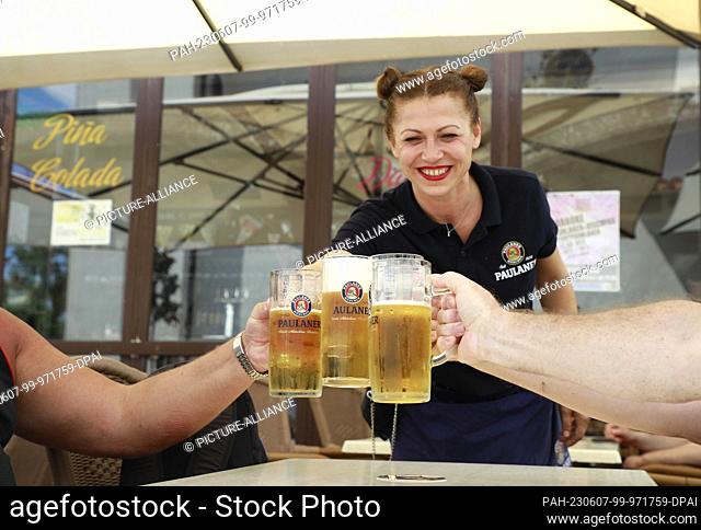 05 June 2023, Spain, Palma: A waitress at the cult restaurant ""Münchner Kindl"" serves beer to some customers. Photo: Clara Margais/dpa