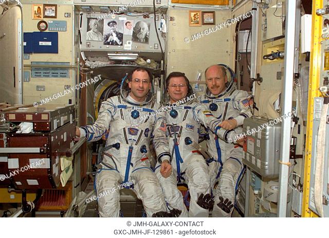 Attired in their Russian Sokol suits, the Expedition Six crewmembers pose for a crew photo in the Zvezda Service Module on the International Space Station (ISS)