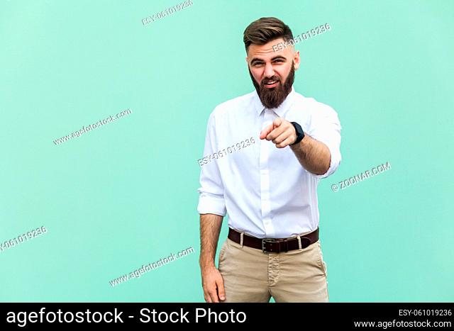 The bearded man pointing finger at camera and mockery over someone. Indoor, studio shot