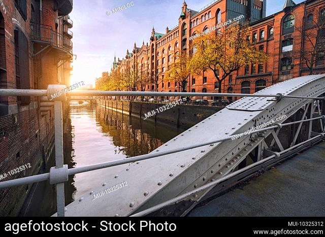 Arch bridge over canals in the historic warehouse district of Hamburg in the warm light of sunset, Germany, Europe