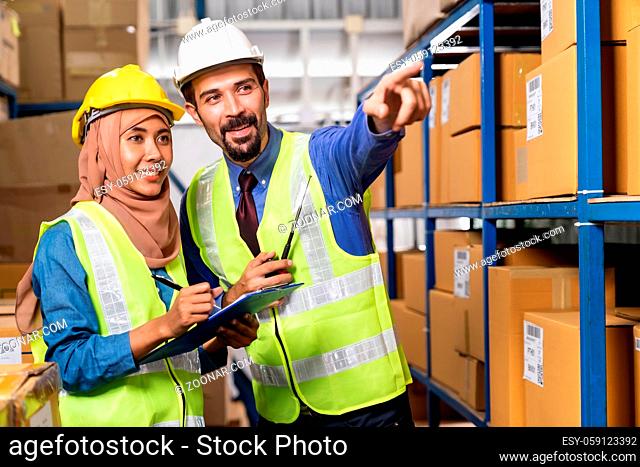 White caucasian warehouse manager command and assign job to muslim asian warehouse worker in distribution center. For business warehouse inventory and logistic...