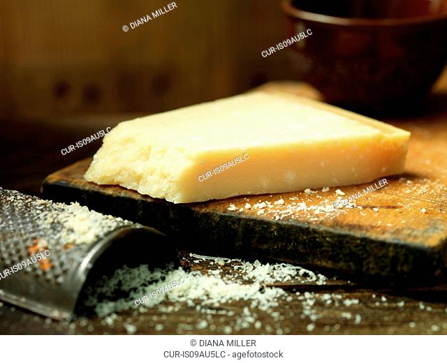 Parmigiano Reggiano cheese, grated on wooden chopping board
