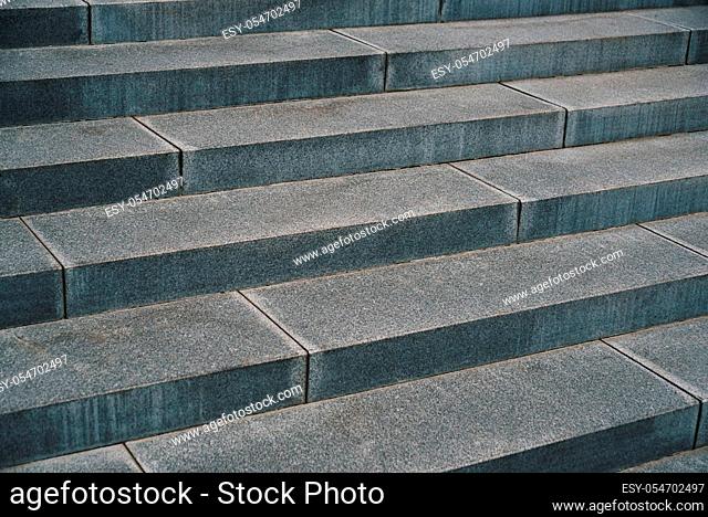 Close up outdoor perspective view of an ancient stone staircase. Pattern of long grey steps. Geometric image with oblique lines